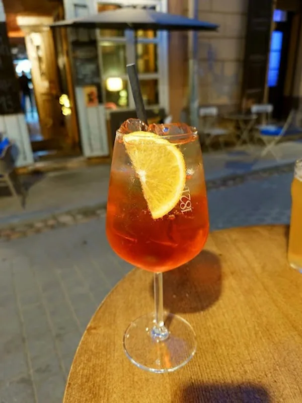 Original phone photo of a spritz on a cafe table at night